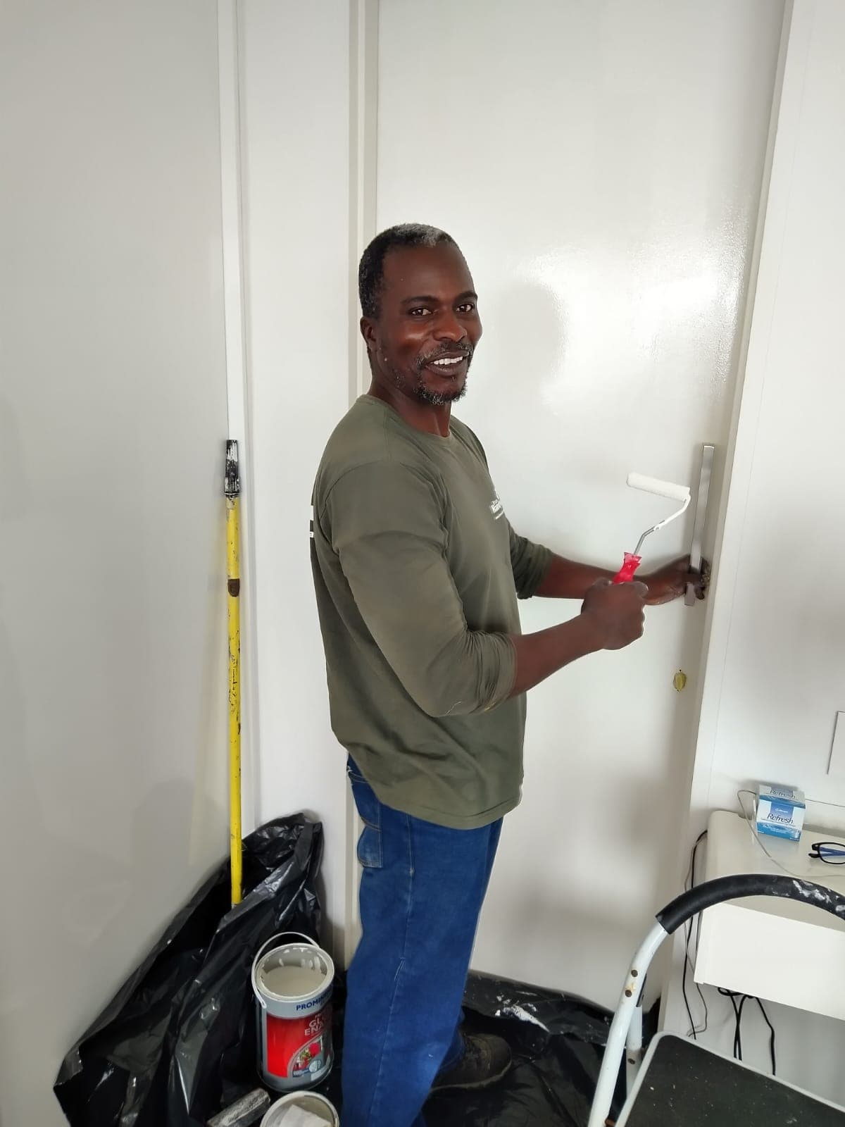 Bruce smiling while painting a door on a job in Cape Town